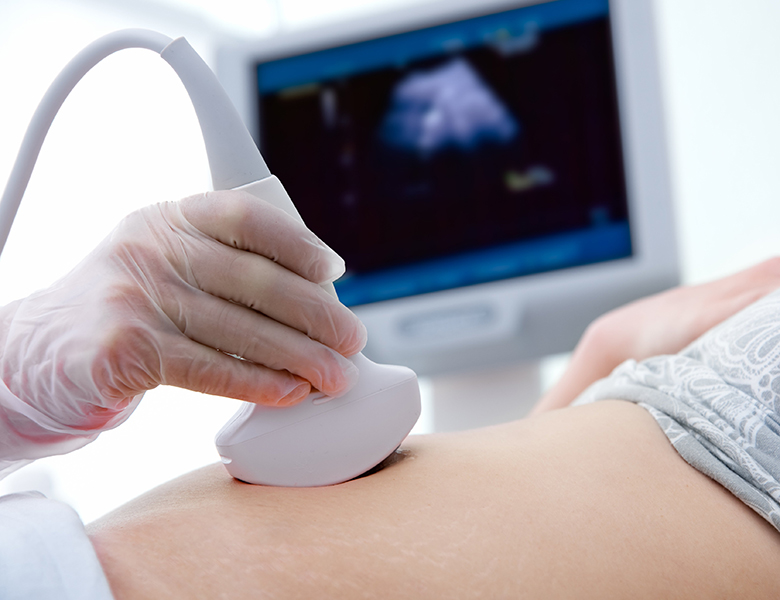 Pregnant woman getting ultrasound from doctor